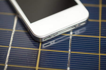 Green energy concept - Mobile Phone charging with solar powerの写真素材