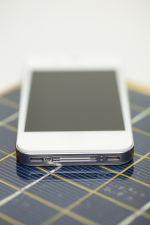 Green energy concept - Mobile Phone charging with solar powerの写真素材