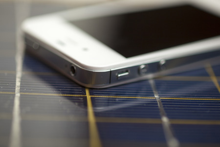 Green energy concept - Mobile Phone charging with solar powerの写真素材