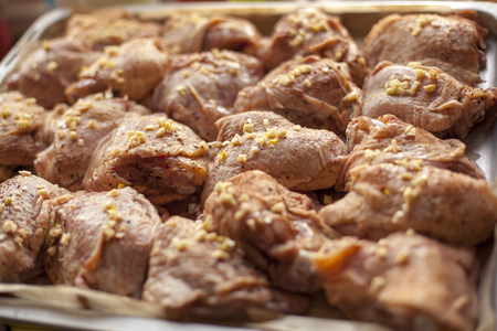 Chicken pieces ready for baking in the oven, with onion and garlic pepper salt marinadeの写真素材