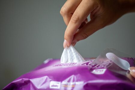Young woman open package of antibacterial wet wipes to cleaning hands