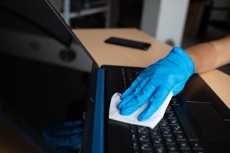 Work from home safe, cleaning and disinfecting laptop computer with wet wipes
