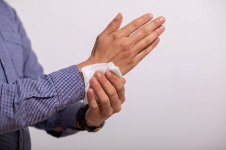 Young man cleaning hands with wet wipesの写真素材