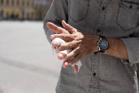 Old man cleaning hands with wet wipes, whiteの写真素材