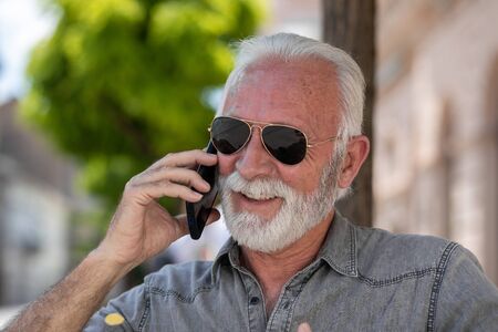 Old tourist man use internet communication app to speak free  in roamingの写真素材