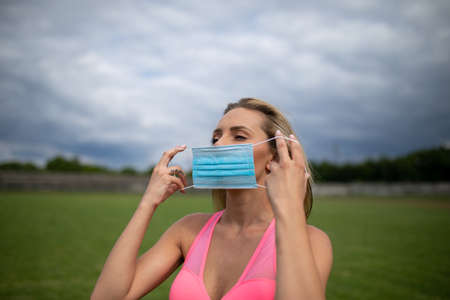 Wearing face mask on the sports field, preparations for training with virus prevention measures