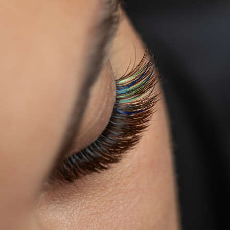 Treatment of Eyelash Extension with diferent colors. Lashes. Woman Eyes with Long Eyelashes in diferent color.の写真素材