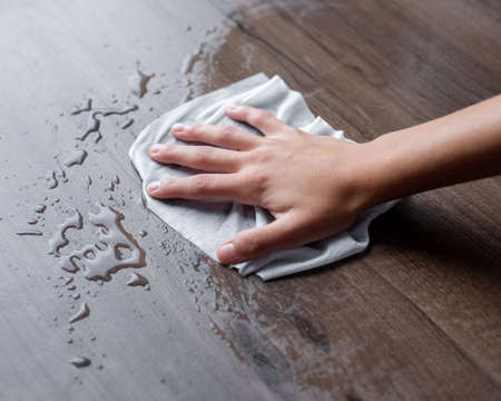 Woman hand clean cleaning liquid water drops with wipe or tissues
