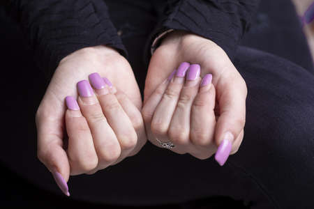 Overgrown manicure. Female hands with overgrown nails. Time for correction gel polish. nail care concept stock photoの写真素材