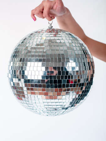 Hand holding Shining Disco Ball dance music event equipment isolated on white backgroundの写真素材
