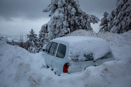 Car stuck in deep snow on mountain road - winter traffic problem stock imageの写真素材