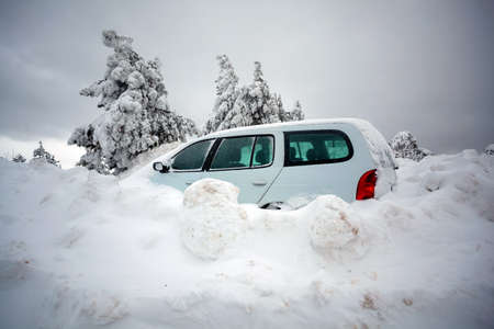 Car stuck in deep snow on mountain road - winter traffic problem stock imageの写真素材