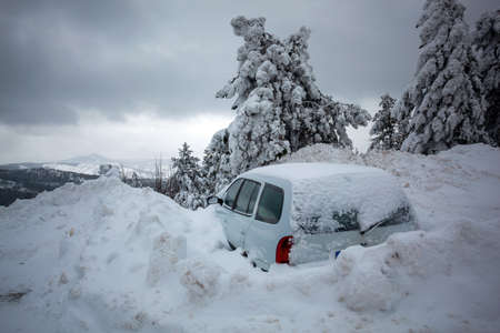 Car stuck in deep snow on mountain road - winter traffic problem stock imageの写真素材