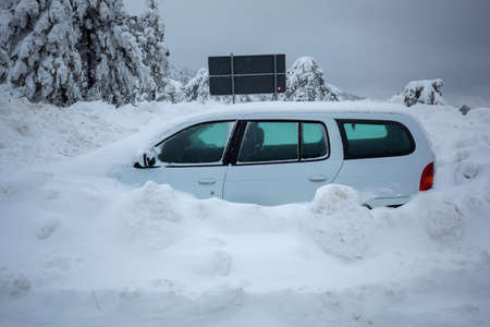 Car stuck in deep snow on mountain road - winter traffic problem stock imageの写真素材