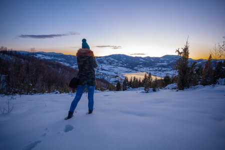 Photographers photographing winter lake mountain scene in sunset, alone in wilderness. Rovni, Valjevo, Serbiaの写真素材