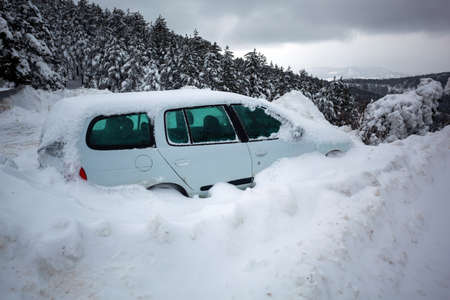 Car stuck in deep snow on mountain road - winter traffic problem stock imageの写真素材
