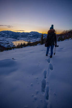 Photographers photographing winter lake mountain scene in sunset, alone in wilderness. Rovni, Valjevo, Serbiaの写真素材