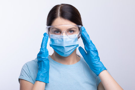 Nurse or doctor wearing and checking protective equipment against viruses and bacterial disease stock photoの写真素材