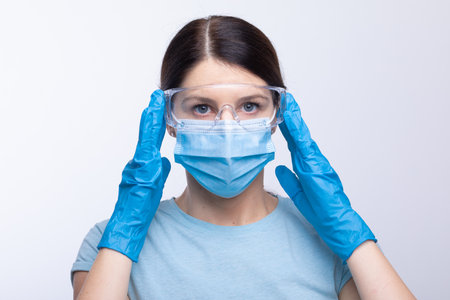 Nurse or doctor wearing and checking protective equipment against viruses and bacterial disease stock photoの写真素材