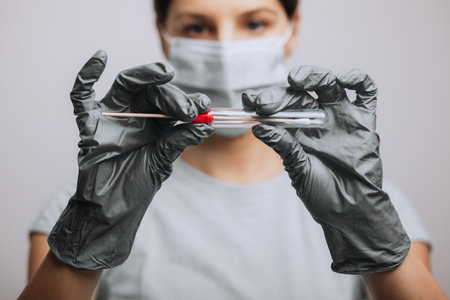 Medical healthcare nurse holding swab test kit, PPE protective mask and gloves, tube for taking OP...