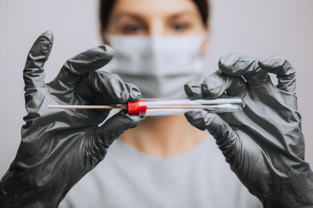 Medical healthcare nurse holding swab test kit, PPE protective mask and gloves, tube for taking OP NP patient specimen sample, PCR DNA RNA testing protocol process stock photoの写真素材