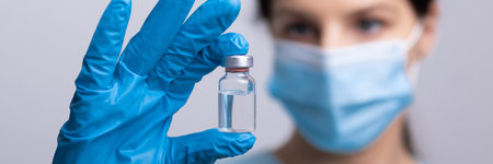 Doctor scientist with protective gloves and face mask holding vaccine medicine dose stock photoの写真素材
