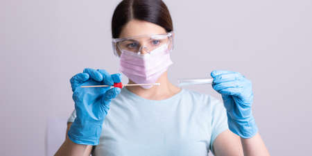 Medical healthcare doctor nurse holding Coronavirus COVID-19 swab test kit, PPE protective mask and gloves, tube for taking OP NP patient specimen sample, PCR DNA RNA protocol process stock photoの写真素材