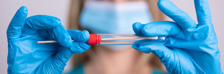 Nurse with facemask holding swab test kit, PPE protective mask and gloves, tube for taking OP NP patient specimen sample, PCR DNA RNA testing protocol process stock photoの写真素材