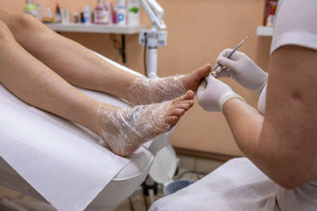 Female foot in process of pedicure procedure treatment stock photoの写真素材