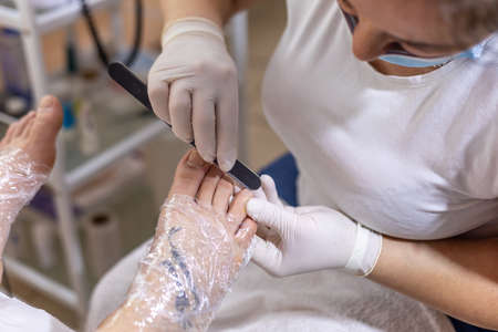 Female foot in process of pedicure procedure treatment stock photo