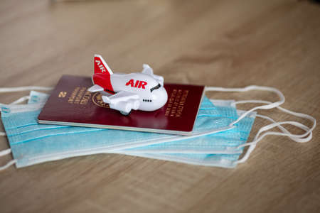 Airline Traveling in new reality post covid: face mask, passport and airplaneの写真素材