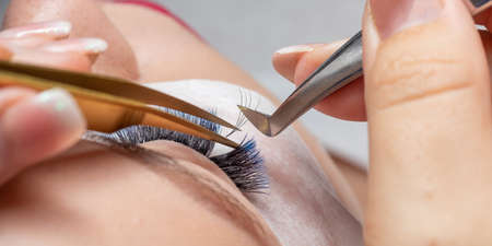 Treatment of Eyelash Extension with blue colors. Lashes. Woman Eyes with Long Eyelashes in diferent...