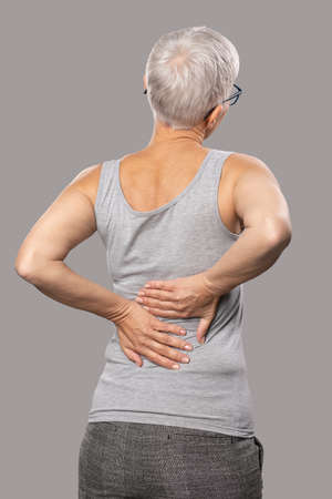 Pain in the back. Shoulder pain, old woman with body and muscle problems, healthcare and medicine concept. back viewの写真素材