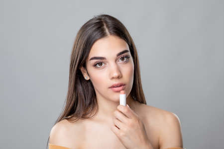 Young beautiful beauty woman applying lipstick or lip balm, skin and lips care, Chap protectionの写真素材
