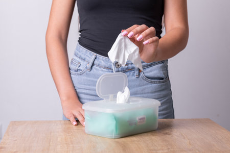 Woman with light pink nails taking wet wipes from the disposable package - hygiene procedure and prevention of infectious diseases stock photoの写真素材