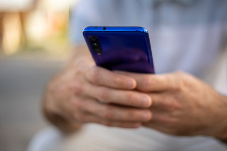 Closeup shot of an unrecognizable man holding mobile smartphone in hand,  chatting via internet applicationの写真素材