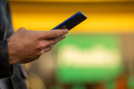 Closeup shot of an unrecognizable man holding mobile smartphone in hand,  chatting via internet applicationの写真素材