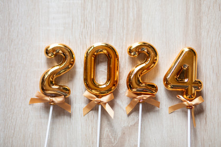 Happy New Year 2024 concept - Orange gold numbers on light wooden background stock photoの写真素材