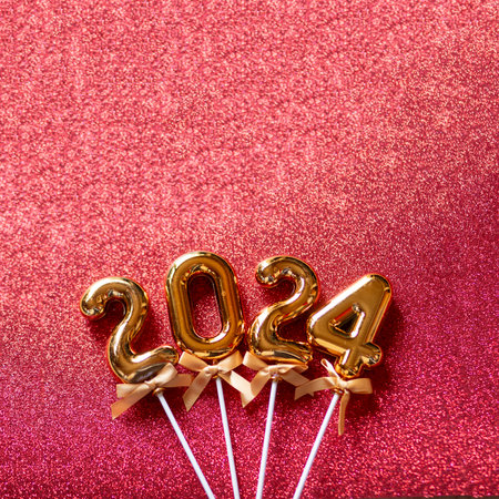 Happy New Year numbers 2024 concept - Orange old gold numbers on red glitter background stock photoの写真素材