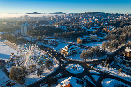 Panoramic aerial view of Zlatibor amusement park and low cloud over Zlatibor Mountain at winter sunset, Cajetina, Serbia.の写真素材