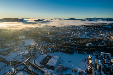 Panoramic aerial view of Zlatibor town and low cloud over Zlatibor Mountain at winter sunset, Cajetina, Serbia.の写真素材