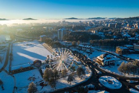 Panoramic aerial view of Zlatibor amusement park and low cloud over Zlatibor Mountain at winter sunset, Cajetina, Serbia.の写真素材