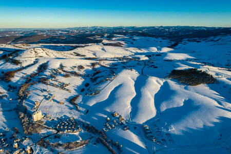 Panoramic aerial view of Zlatibor town and low cloud over Zlatibor Mountain at winter sunset, Cajetina, Serbia.の写真素材