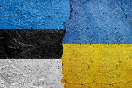 Estonia and Ukraine - Cracked concrete wall painted with a Estonian flag on the left and a Ukrainian flag on the rightの写真素材
