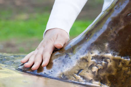 hand of the girl ironing a monument for luck in clear summer dayの写真素材
