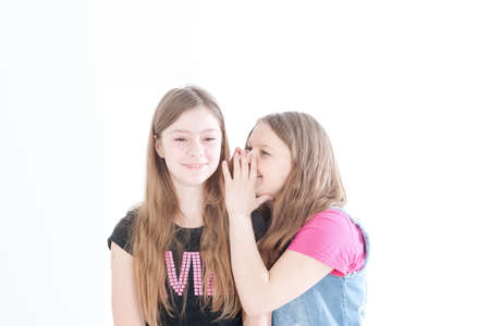 two smiling young beautiful girls on a white backgroundの写真素材