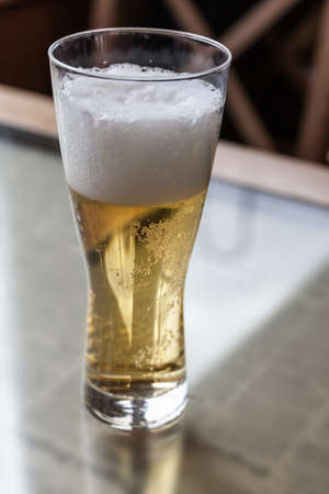 Glass with beer on a table in cafeの写真素材