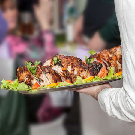 waiter giving a meat dish at restaurantの写真素材