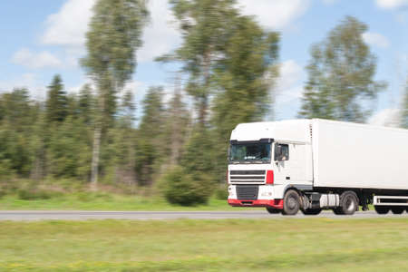 the truck goes on the highway in summer day, an indistinct background