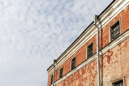 wall of prison with barred windows in clear day